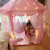 子供のテート室内のお姫様人形のおもちゃ屋さんの大きなお城でままごとをして歌を歌っています。家の女の子はベッドの神器のピンクを分けています。